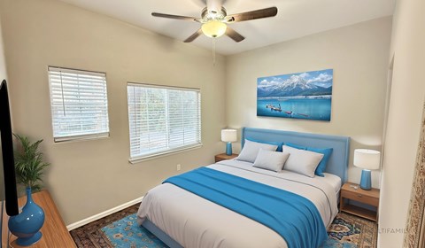 A bedroom with a bed, a ceiling fan, and a painting of a mountain scene on the wall.