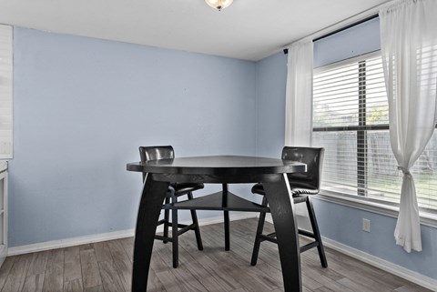 A dining room with a table and chairs.