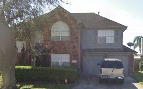 A house with a white car in front.
