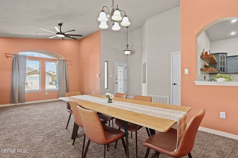 A dining room with a long table and chairs.