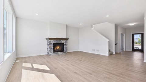A spacious living room with a fireplace and wooden flooring.
