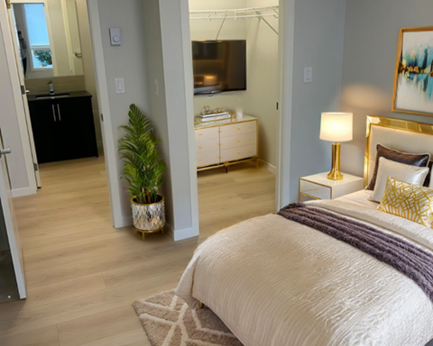 A bedroom with a large bed and a television in the background.