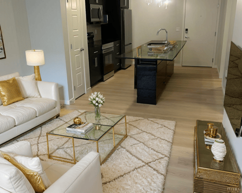 A modern living room with a glass coffee table and white sofa.