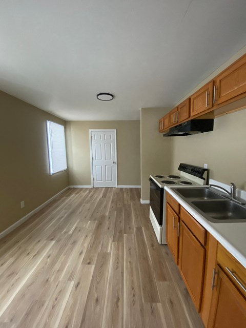 A kitchen with wooden floors and white walls.