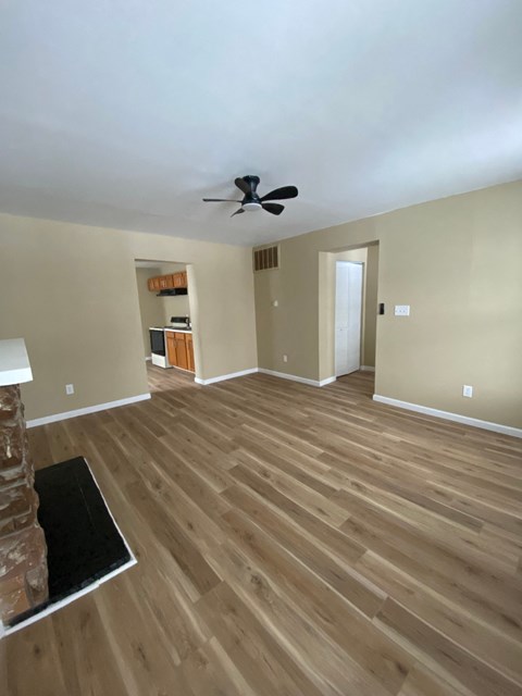 A room with wooden flooring and a ceiling fan.
