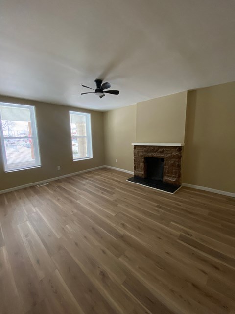 A room with a fireplace and a ceiling fan.