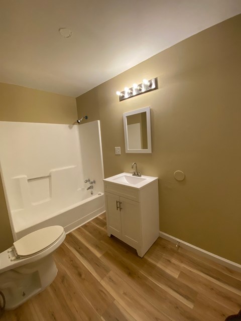 A white toilet sits next to a sink in a small bathroom.