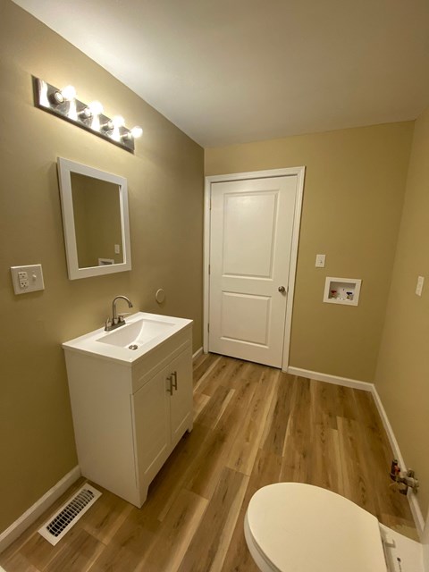 A bathroom with a white sink and a white toilet.