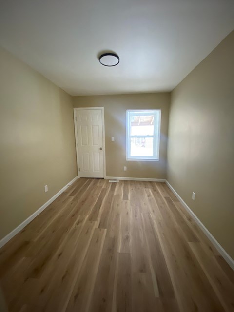 A room with wooden floors and a window.
