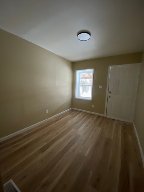 A room with wooden floors and a window.
