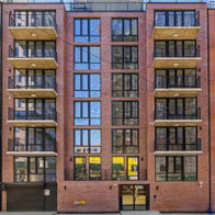 A red brick building with balconies on the second floor.