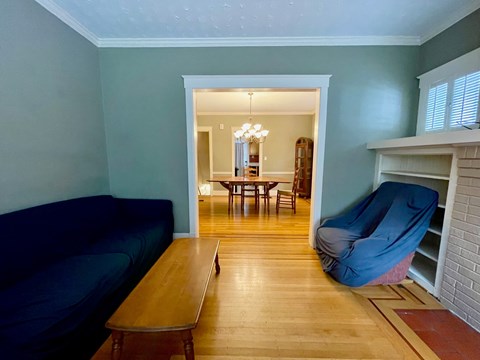 A living room with a blue couch and a wooden table.
