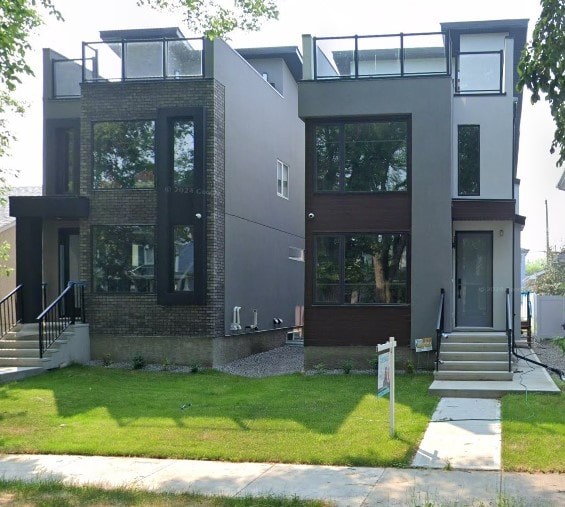 A modern house with a glass balcony on the second floor.