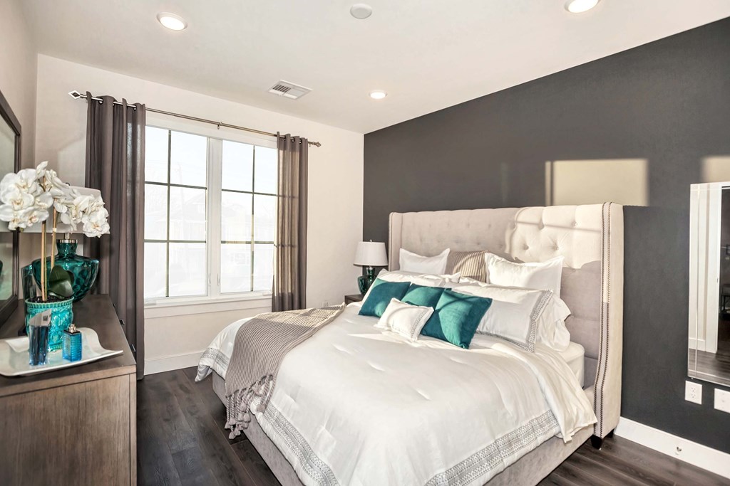 A bedroom with a large bed and a wooden dresser.