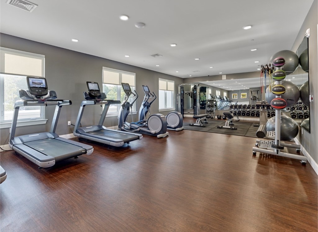 A spacious gym with treadmills, elliptical machines, and a variety of exercise equipment.