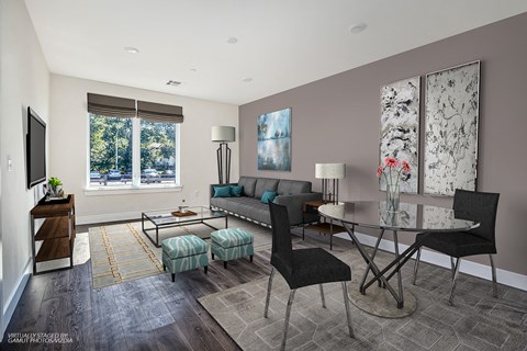 A living room with a grey couch and a black chair.