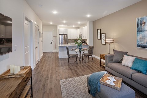 A modern living room with a grey couch and a wooden coffee table.