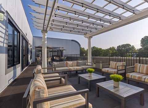 A patio with striped cushions and a white pergola.