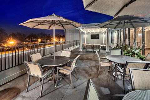 A patio with a table and chairs under umbrellas.