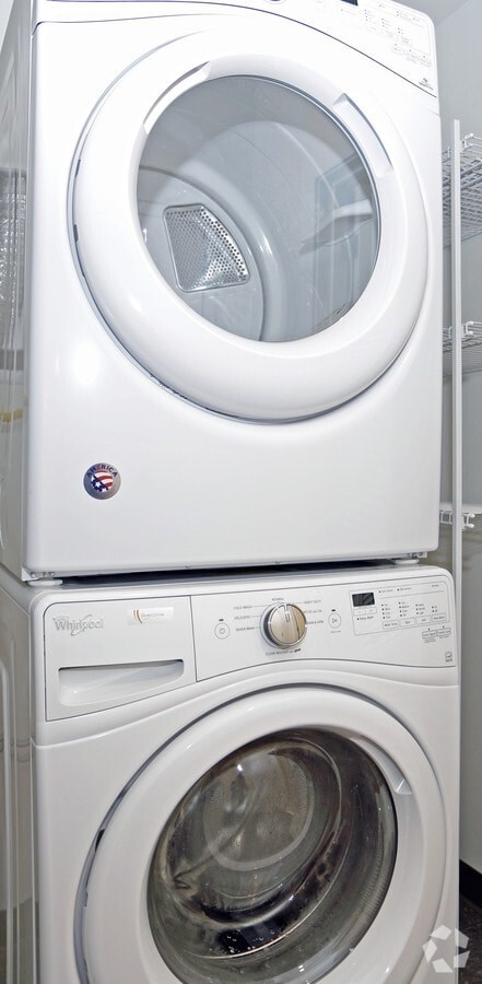 A white washing machine with a dryer stacked on top of it.