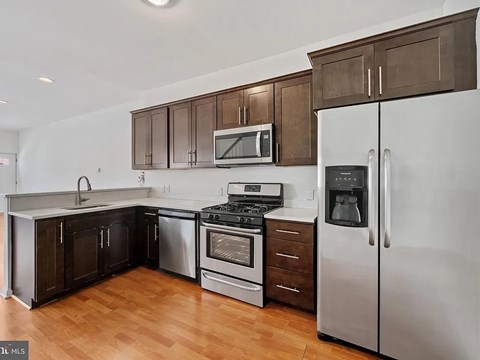 A kitchen with a stove top oven and a refrigerator.