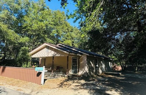 A house with a brown fence and a blue sign in front.