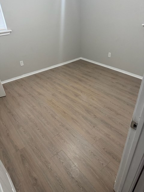 A room with a wooden floor and a white door.