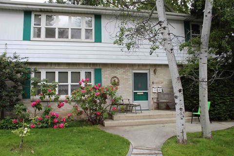 A white house with a green door and a small porch.