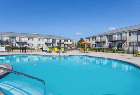 A large swimming pool in front of apartment buildings.