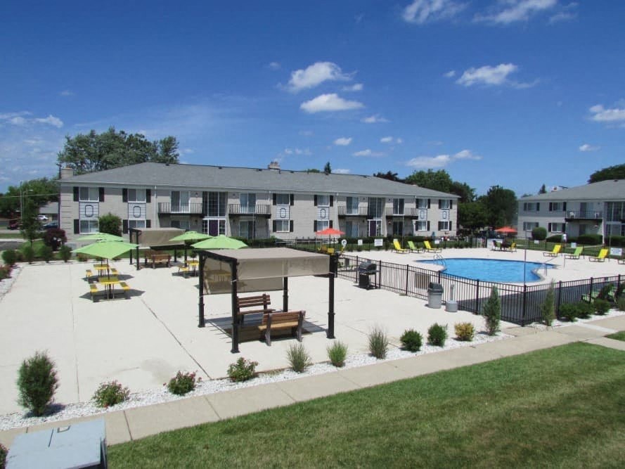A pool area with a building in the background.
