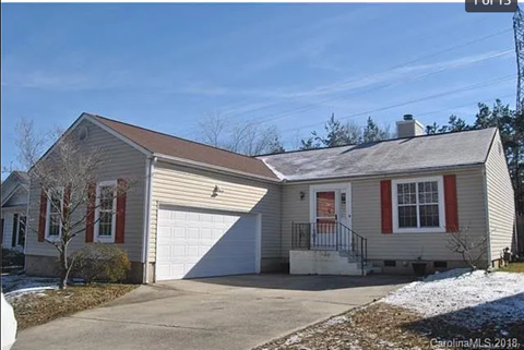 A house with a garage and a driveway in front.