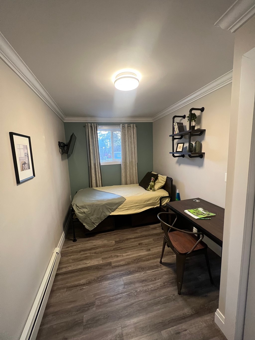 A bedroom with a bed, desk, and chair.