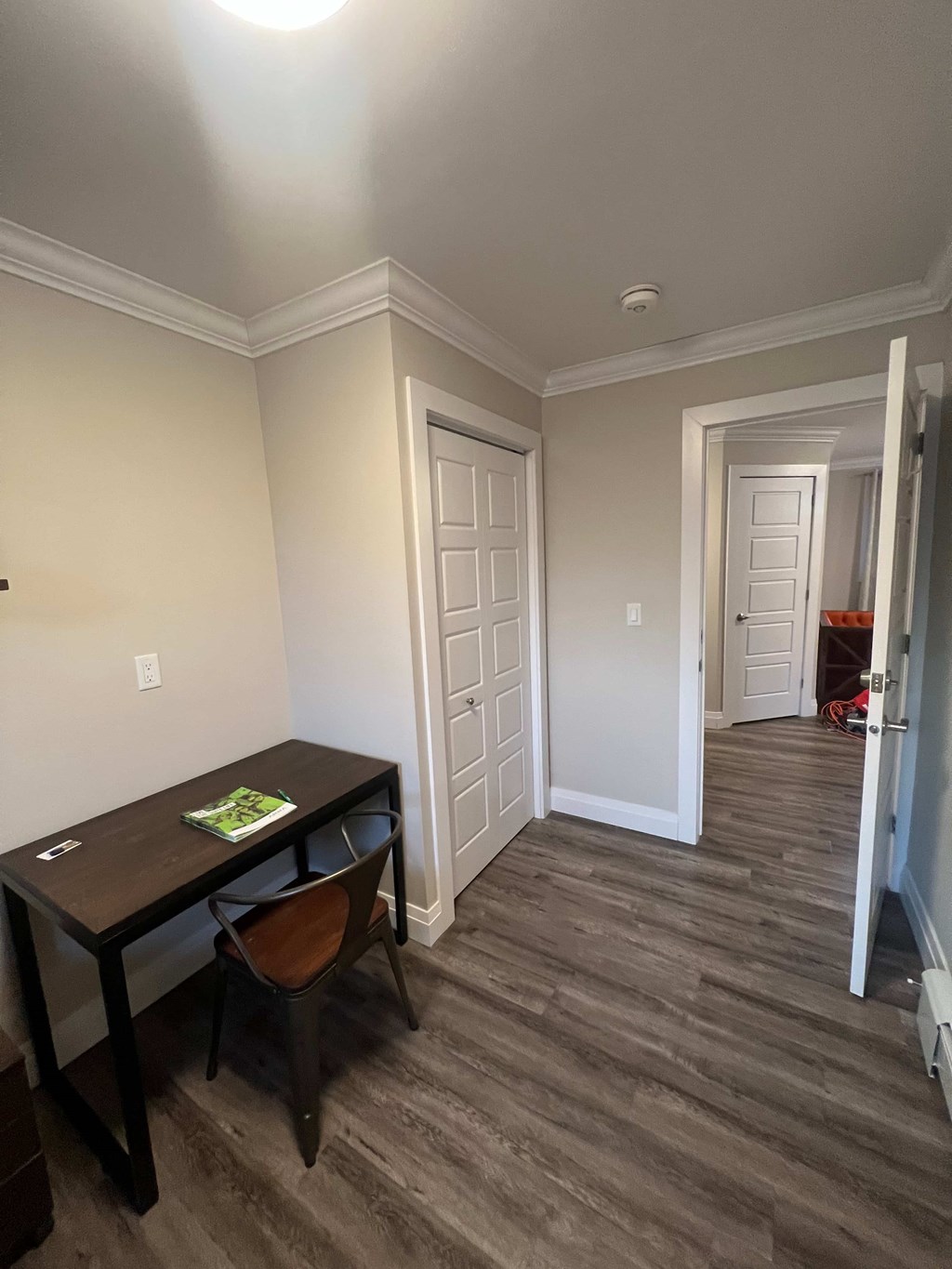 A room with a desk and chair in it.