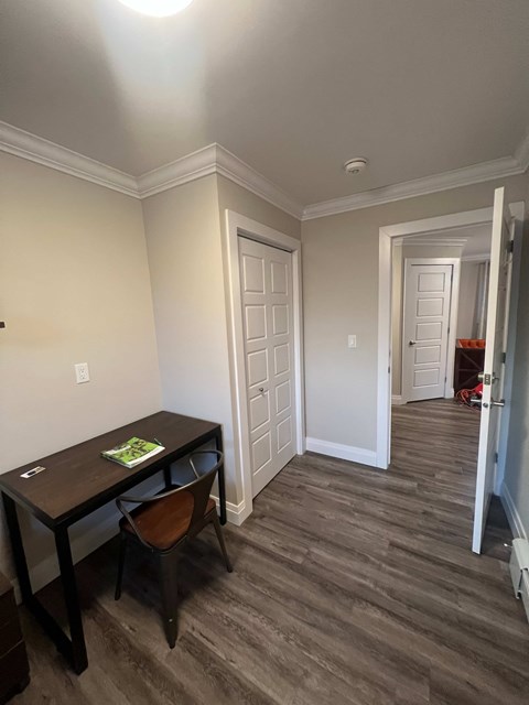 A room with a desk and chair in it.