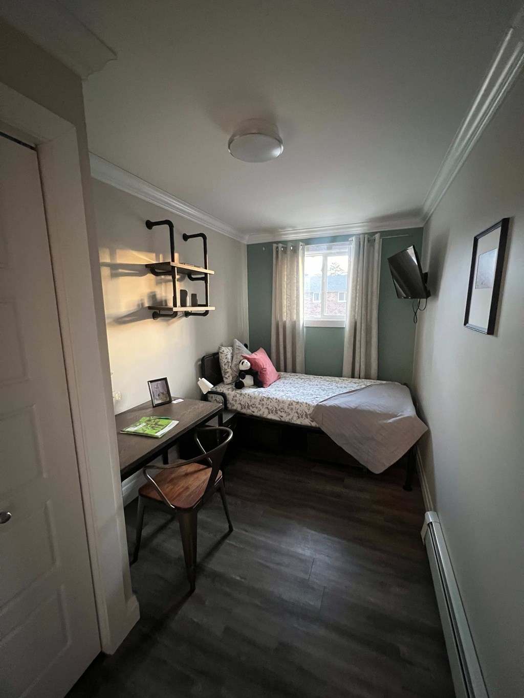 A small room with a bed, desk, and chair.