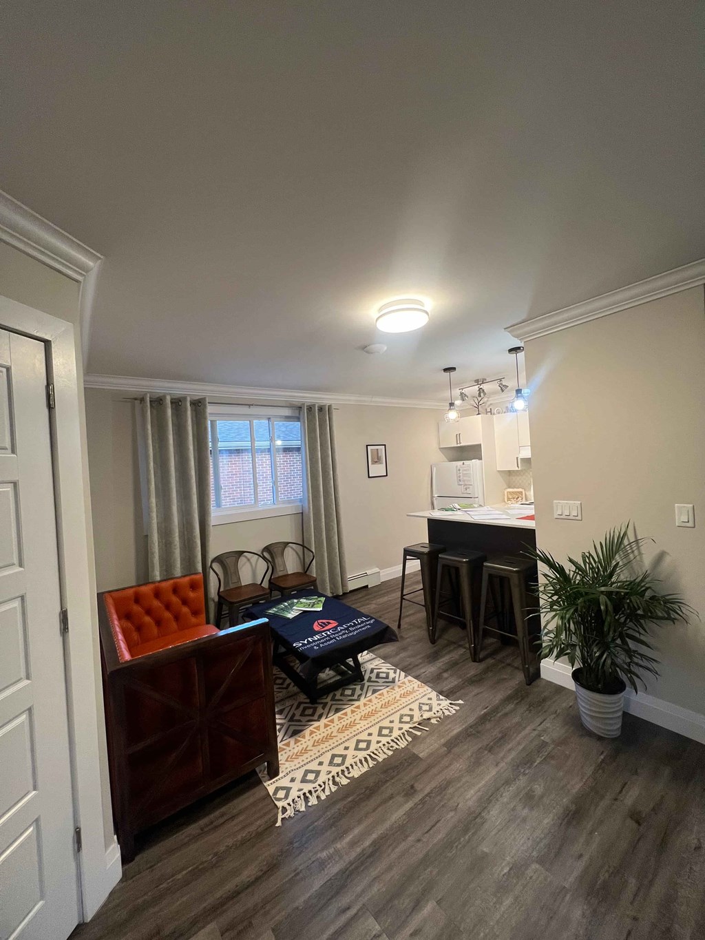 A living room with a red chair and a wooden floor.