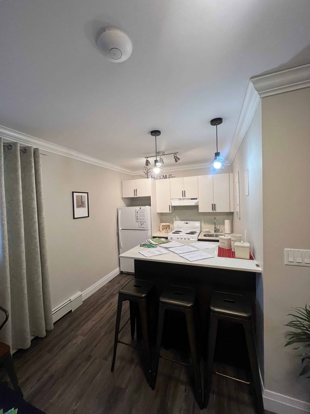 A kitchen area with a table and chairs.