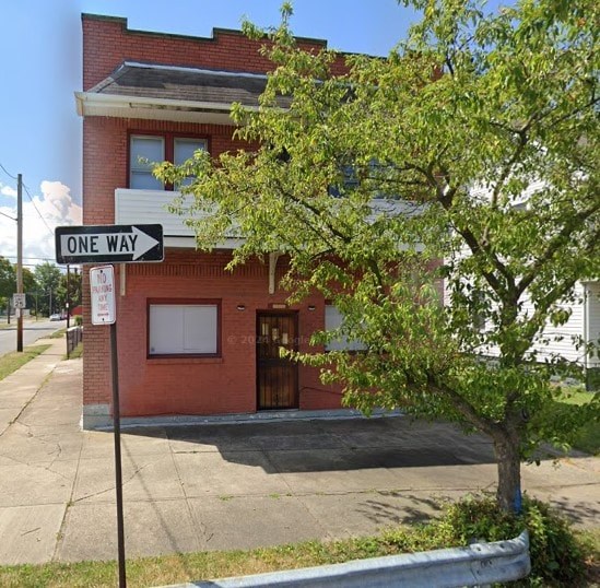 A red brick building with a tree in front of it.