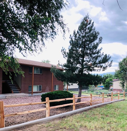 A red brick building with a wooden fence in front of it.