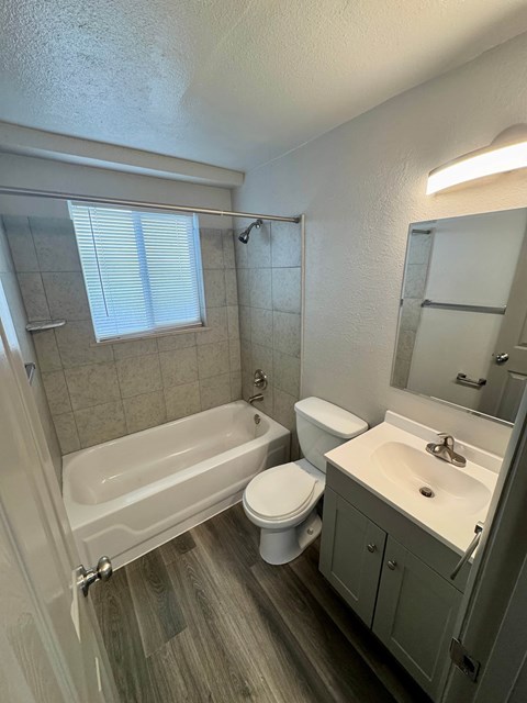 A white bathroom with a tub, toilet, and sink.