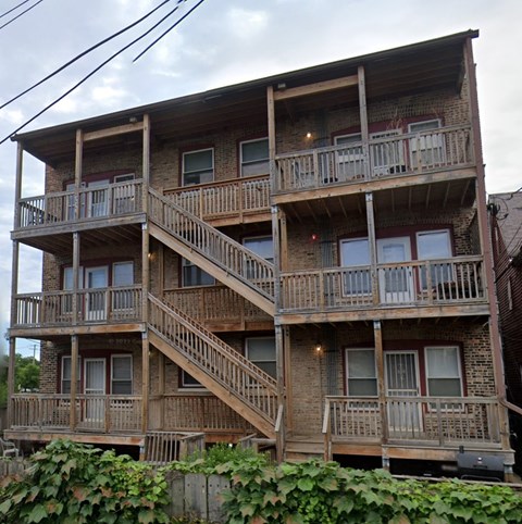 A large wooden apartment building with multiple balconies and staircases.