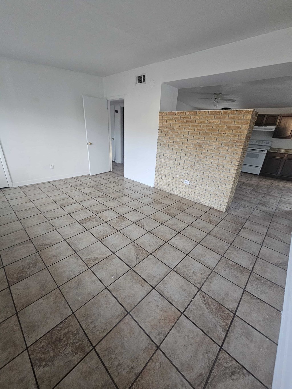 A room with a tiled floor and a brick wall.