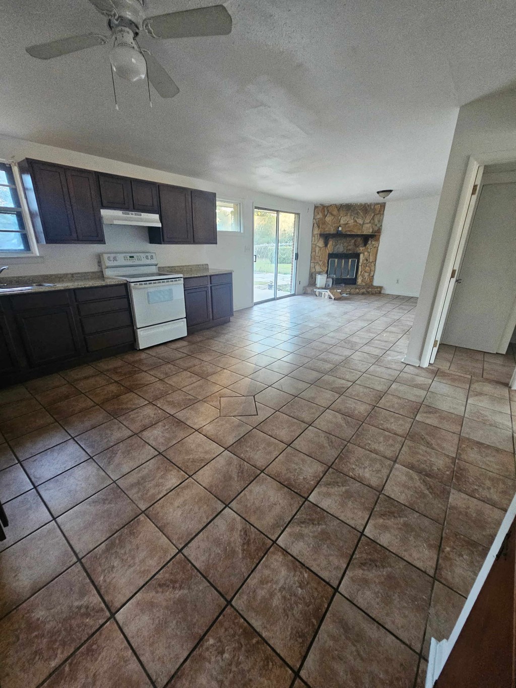 A kitchen with tile flooring and a ceiling fan.