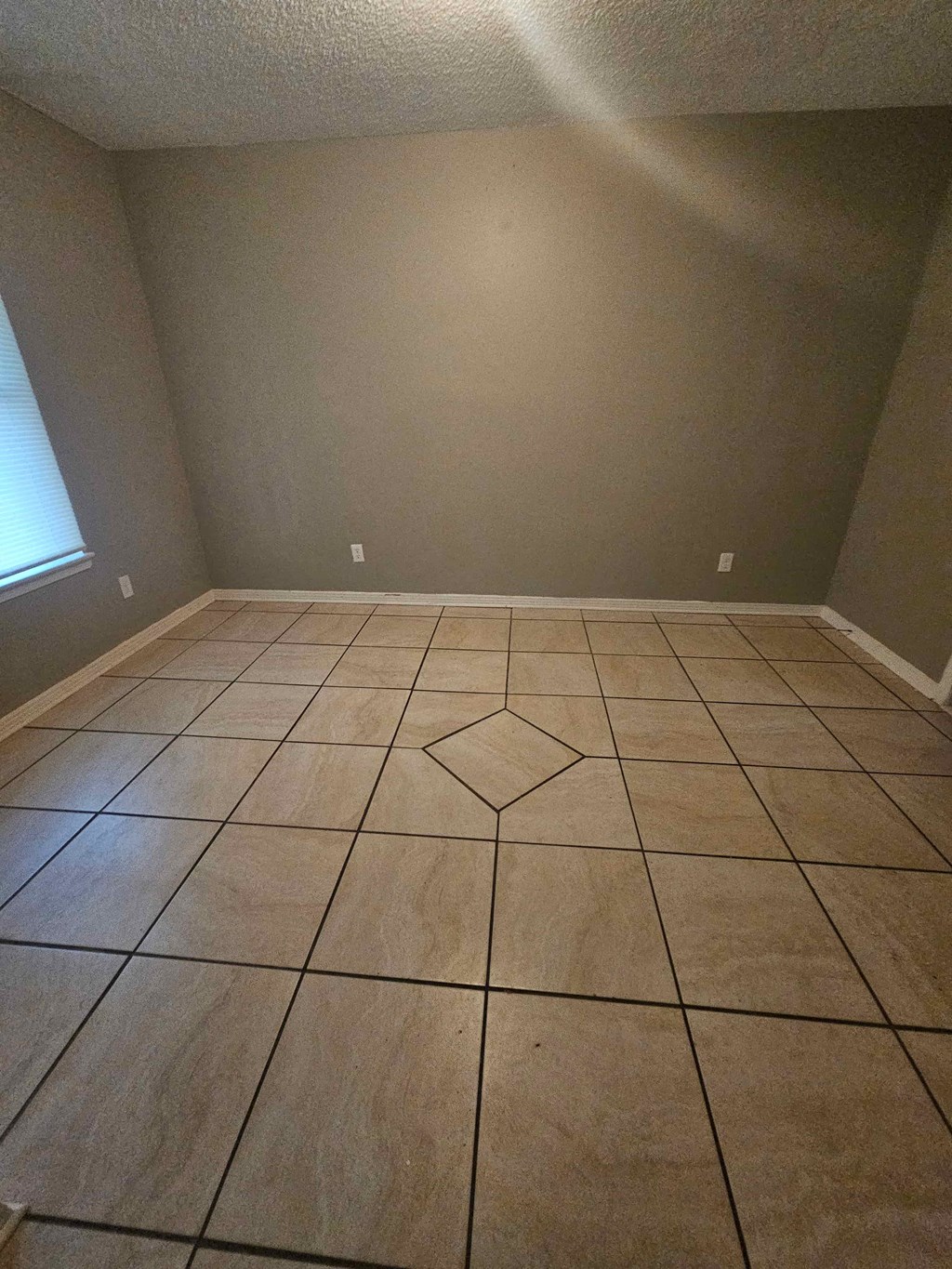 A room with a tile floor and a window.