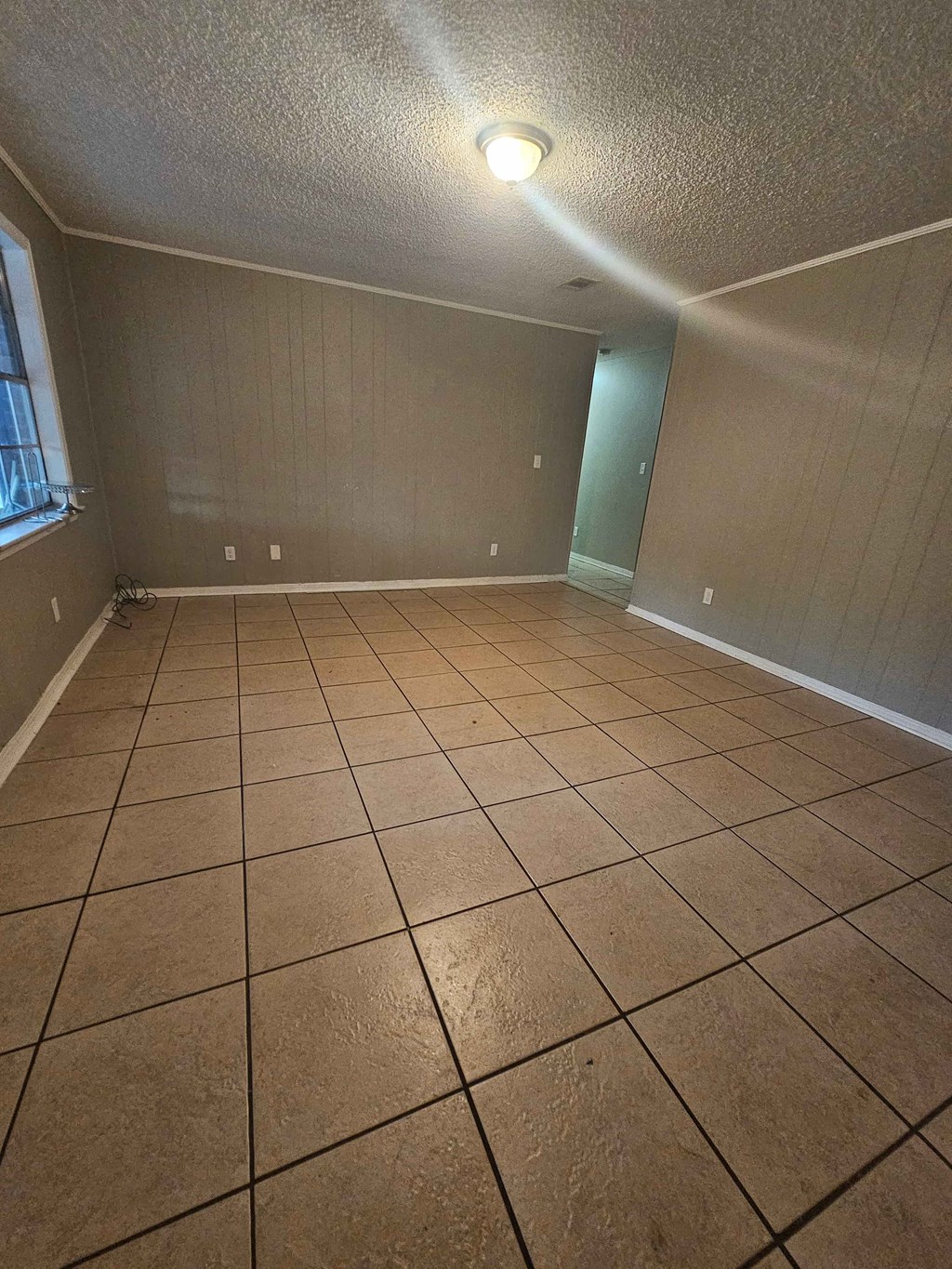 A room with tile flooring and a light on the ceiling.