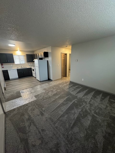 A kitchen with black cabinets and white appliances.