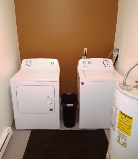 Two white washing machines in a small room.