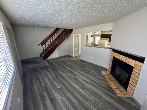A living room with a fireplace and a staircase.