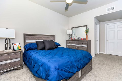 A bedroom with a blue comforter on the bed.