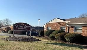 A sign for Spyglass Street is in front of a house.
